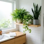 Boston fern, pothos and snake plant on a shelf by a frosted window in a bright bathroom
